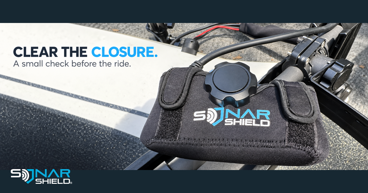 Installed black Sonar Shield neoprene transducer cover with two fastening tabs and clear closure-check headline.